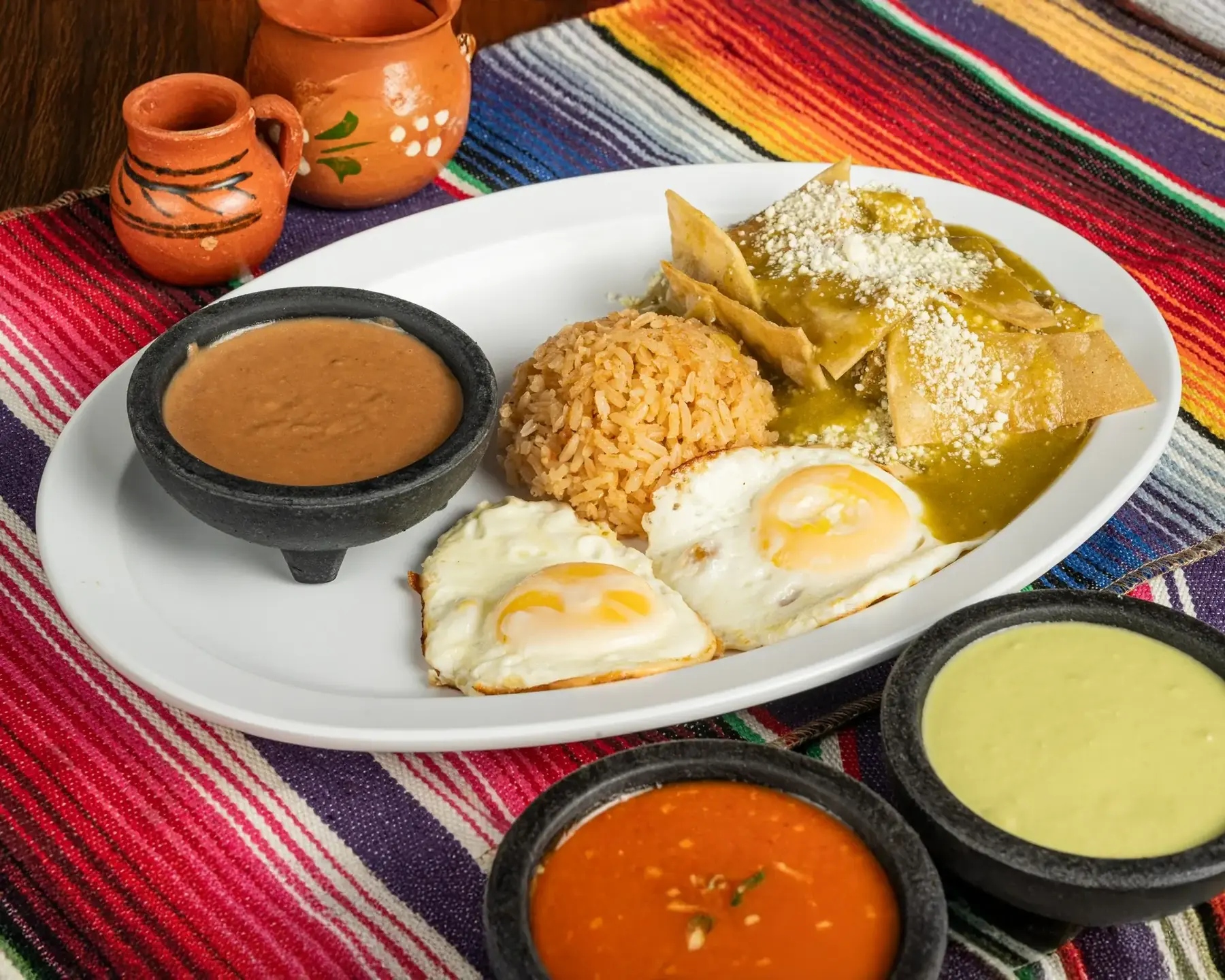 Mexican brunch plate of huevos with rice, refried beans and salsa verde at Autentica Taqueria in Kendall, Miami