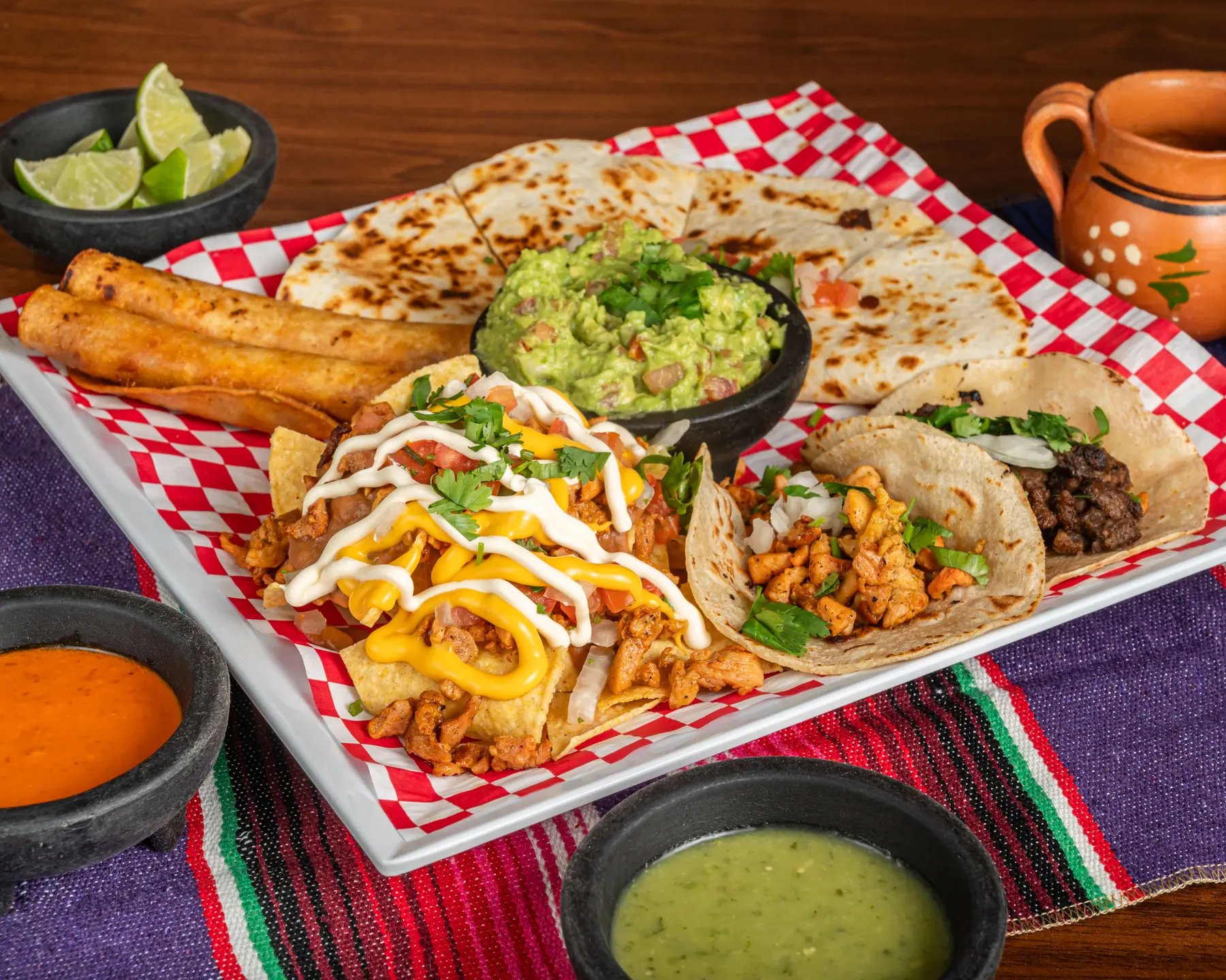 Sharing platter of tacos, flautas, guacamole and churros served with handmade tortillas at Autentica Taqueria in Kendall