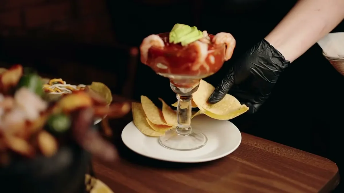 A shrimp cocktail served in a tall glass with tortilla chips at Autentica Taqueria