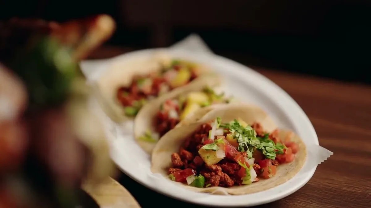 Street tacos on a white plate at Autentica Taqueria in Kendall, Miami